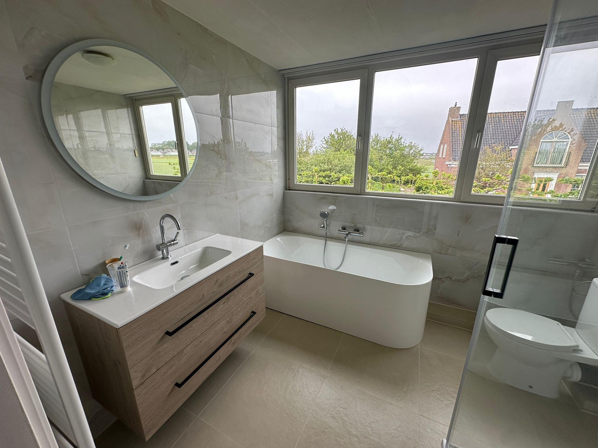 Badkamer met vrijstaand bad en uitzicht, gerealiseerd door Bollenstreek Badkamers