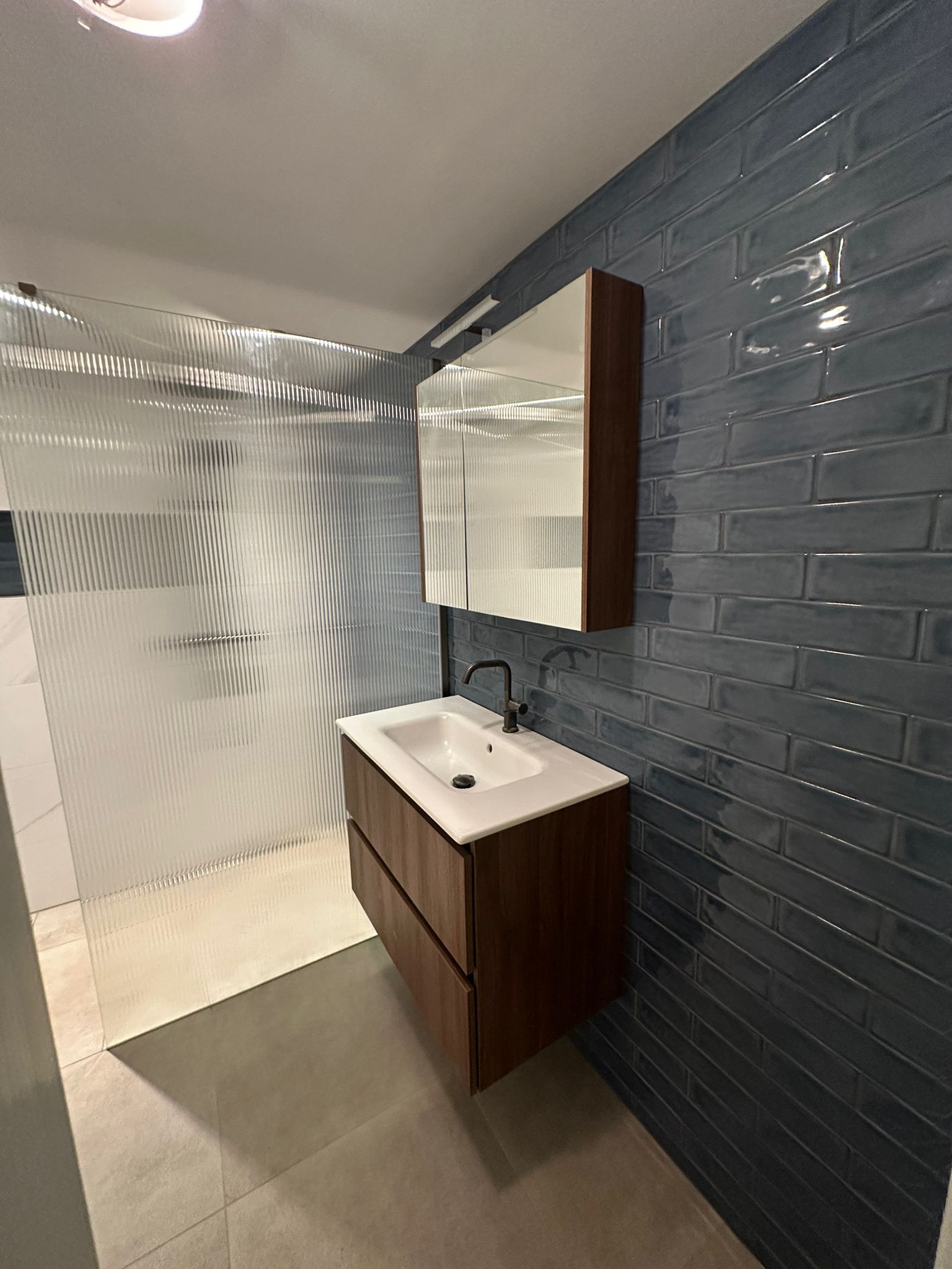 Walnoten badmeubel met wit marmer en marineblauw subway-tegelaccent
